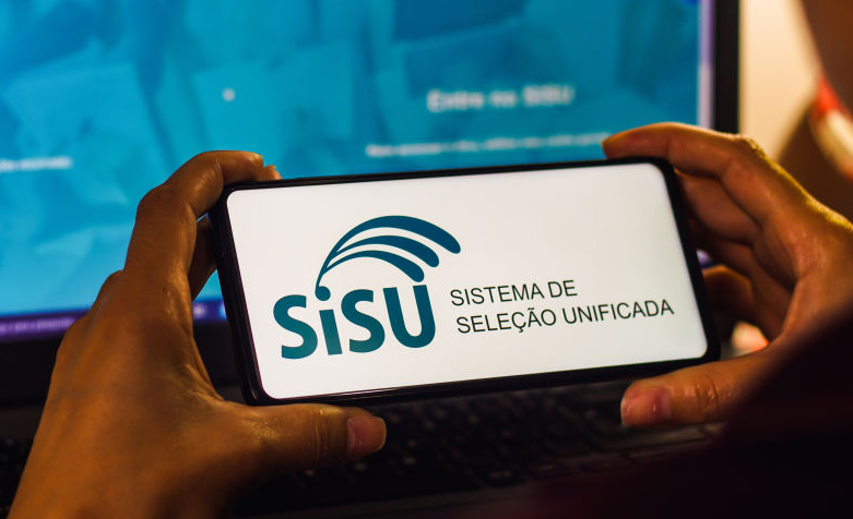Imagem de um estudante segurando um celular no site do SISU